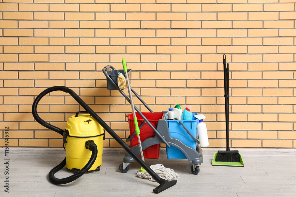 Φωτογραφία Janitor's trolley with cleaning supplies, floor mop and vacuum cleaner near bric