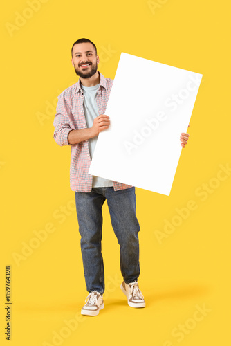 Young man with blank poster...