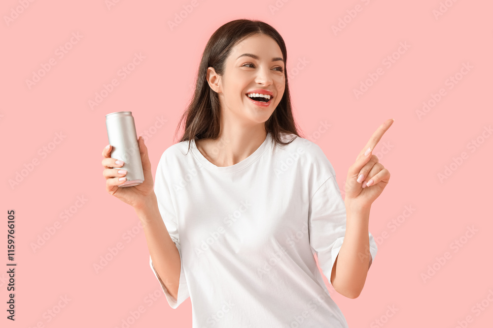 Beautiful young woman with can of soda pointing at something on pink background Beautiful young woman with can of soda pointing at something on pink background