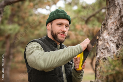 Male lumberjack sawing tree...