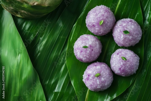 Bualoy a Thai dessert of sticky rice dumplings in sweet coconut milk features purple from taro and green from pandan on banana leaf shown from above in full HD photo