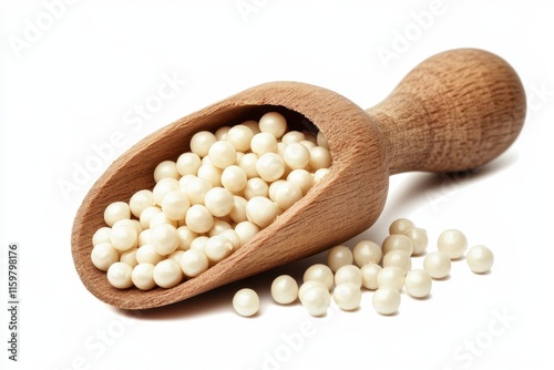 Close up of Job s tears Adlay or pearl millet in a wooden scoop against a white backdrop photo