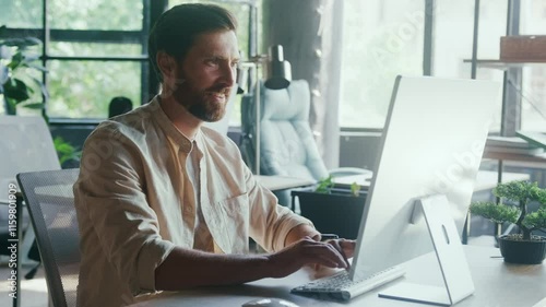 Smiling Man Working at Modern Office Desk with Desktop Computer