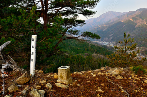 丹沢の秋葉山山頂　頂の三角点に朝日の御正体山と道志村
 photo