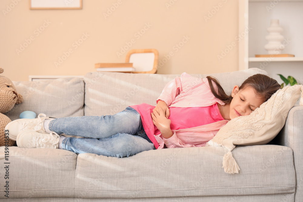 Teenage girl with appendicitis lying on sofa at home Teenage girl with appendicitis lying on sofa at home