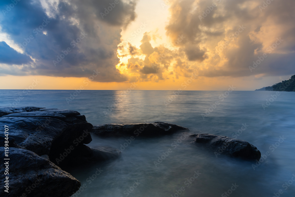 sunrise dramatic sky over sea horizon from rocky shore at dawn long exposure shot sunrise dramatic sky over sea horizon from rocky shore at dawn long exposure shot