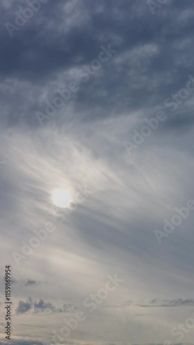 Quality beautiful vertical time lapse of grey sky with sun through clouds