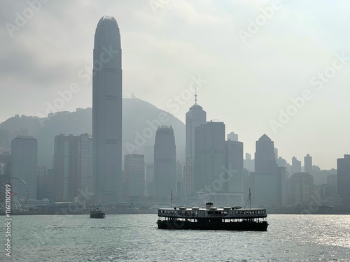 Silhouette of Hong Kong cityscape, commercial residential buildings and star ferry tourist ship