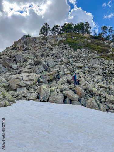 hiker on scree boulder path snow breathtaking mountain ariege pyrenees photo