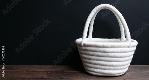 Warm white felt basket on plain black background