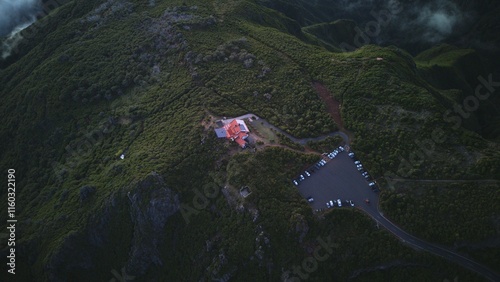Aerial View of Hilltop Building Surrounded by Green Vegetation and Parking Area

