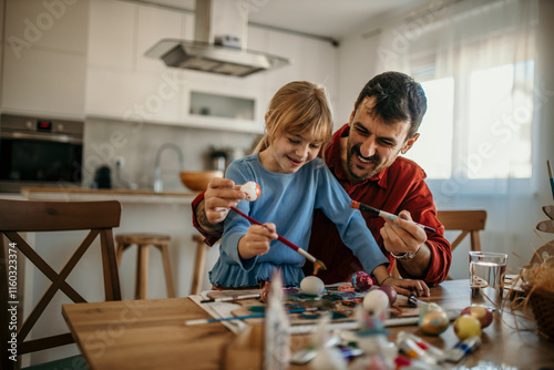 Father and daughter decorating eggs and enjoying quality time together