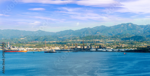 cargo sea port with cranes vehicles, container stacks , supplies and trucks with goods, sea hub terminal from seashore
