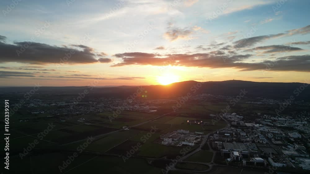 Drone flight at sunset, looking at the Frankfurt Skyline and rural houses in Germany with orange sky Drone flight at sunset, looking at the Frankfurt Skyline and rural houses in Germany with orange sky