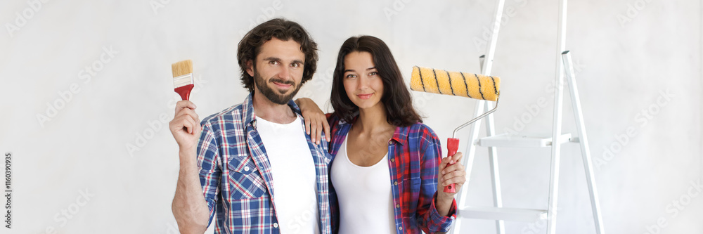 Cheerful couple in casual attire standing with a paintbrush and roller, ready for a DIY home makeover project. Perfect for banner use in concepts of home renovation, interior design, and creative Cheerful couple in casual attire standing with a paintbrush and roller, ready for a DIY home makeover project. Perfect for banner use in concepts of home renovation, interior design, and creative