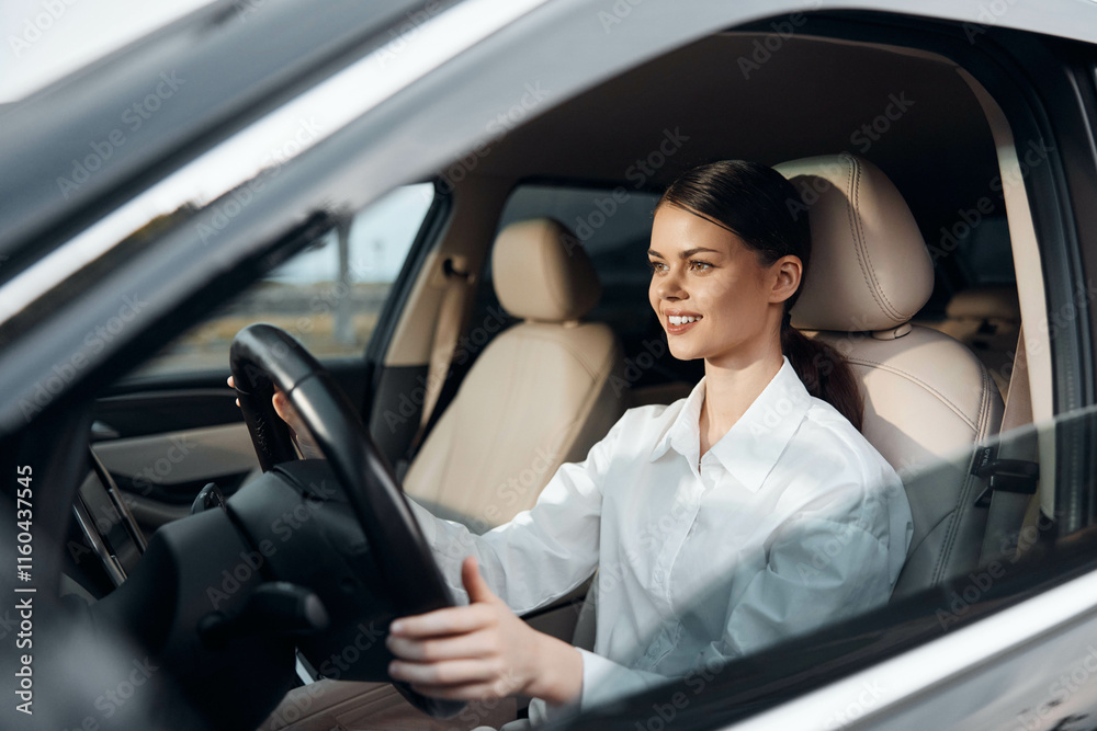 Female driver seated in car, hand on steering wheel, looking at camera Female driver seated in car, hand on steering wheel, looking at camera