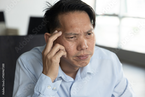 Overworked Asian Man thinking and planning with serious and stressed expression, with mental pressure