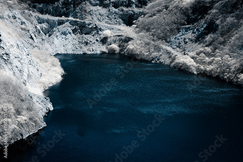 Infrared photography, a body of water surrounded by rocky terrain and sparse vegetation