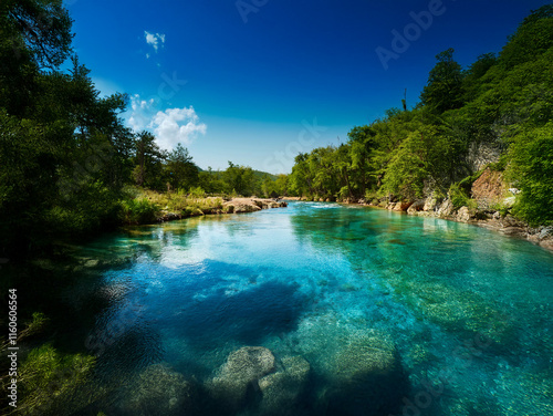 Serene river scene with crystal-clear turquoise water flowing through lush green banks under a vibrant blue sky.  The tranquil atmosphere is perfect for relaxation and contemplation.