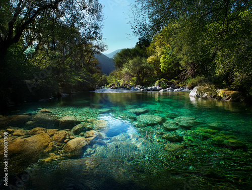 Serene river scene with crystal-clear, turquoise water flowing through a lush green forest.  Sunlit rocks and tranquil atmosphere.