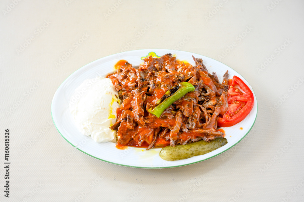Turkish Traditional Ramadan doner kebab with tasty tomato sauce and rice or turkish pilav in white plate on table background. Lavash doner kebab ( doner zurna durum ) Pilavustu Doner Iskender kebap Turkish Traditional Ramadan doner kebab with tasty tomato sauce and rice or turkish pilav in white plate on table background. Lavash doner kebab ( doner zurna durum ) Pilavustu Doner Iskender kebap