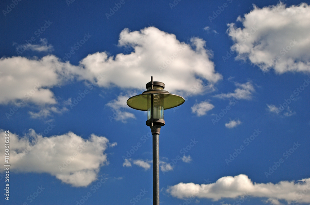 Isolated Modern Outdoor Street Light seen against Blue Sky with White Clouds Isolated Modern Outdoor Street Light seen against Blue Sky with White Clouds
