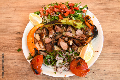 Famous Urfa meat liver, ciger wrapped by lavash with roasted chili pepper, onion and sauce in Sanliurfa, Turkey. Kuzu et ciger sis. Izgara dana bonfile, cop sis, kuzu pirzola. Karisik kebap, beyti keb photo