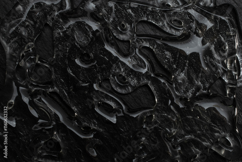 Hot glue smear on black stone background, abstract textured pattern, close up photography photo