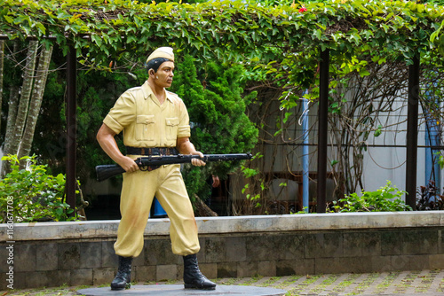 Yogyakarta, Indonesia on 23 Oct 2022. Malioboro. Soldier Statue Holding Rifle Lush Greenery Background photo