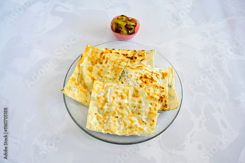 Freshly baked appetizing Turkish tortillas - Gozleme with spinach, cheese  on a wooden board. Space for text. Shallow depth of  field. Handmade traditional  Patatesli, Ispanakli, peynirli gozleme. photo