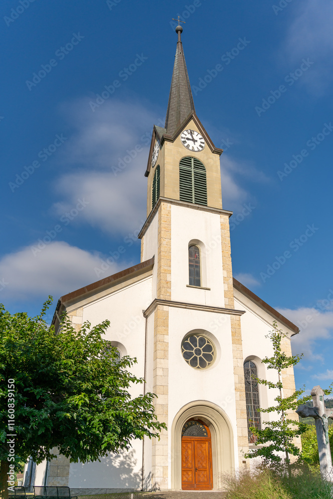 Rural little, but beautiful church behind some trees, and under a blue, slightly clouded sky. Vertical photograph. Rural little, but beautiful church behind some trees, and under a blue, slightly clouded sky. Vertical photograph.