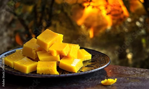 Indian burfi sweets in a black plate near burning logs,  Bhogi festival photo