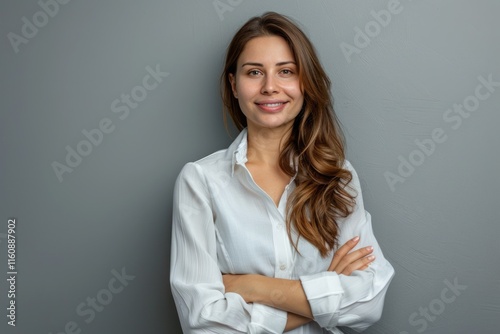 Happy young business woman posing against grey wall background.