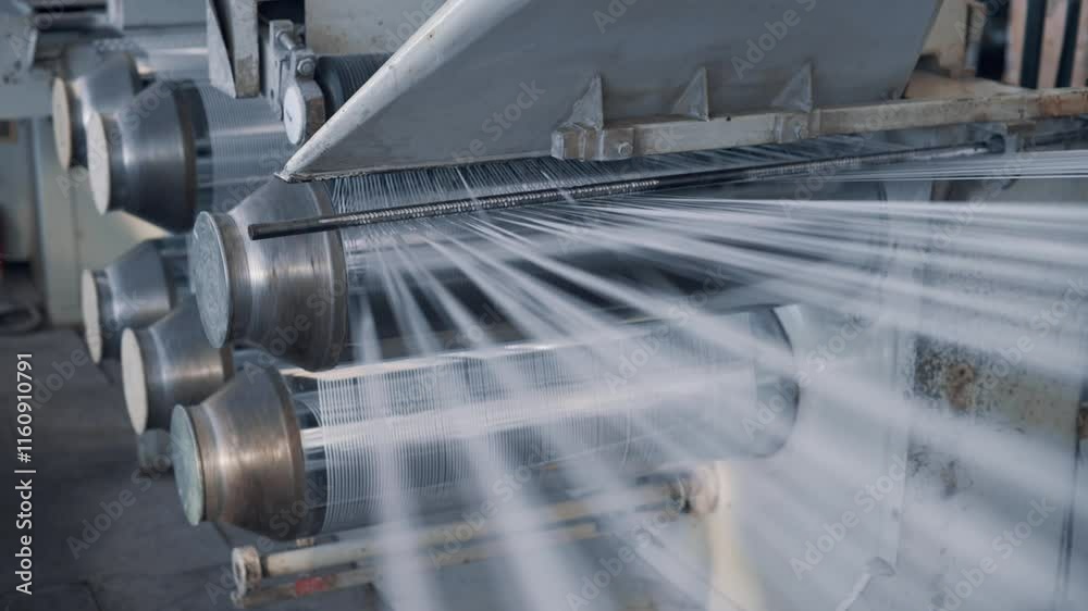 Operation of a flat-slot extruder in the production of polypropylene bags. Close-up of cut threads.