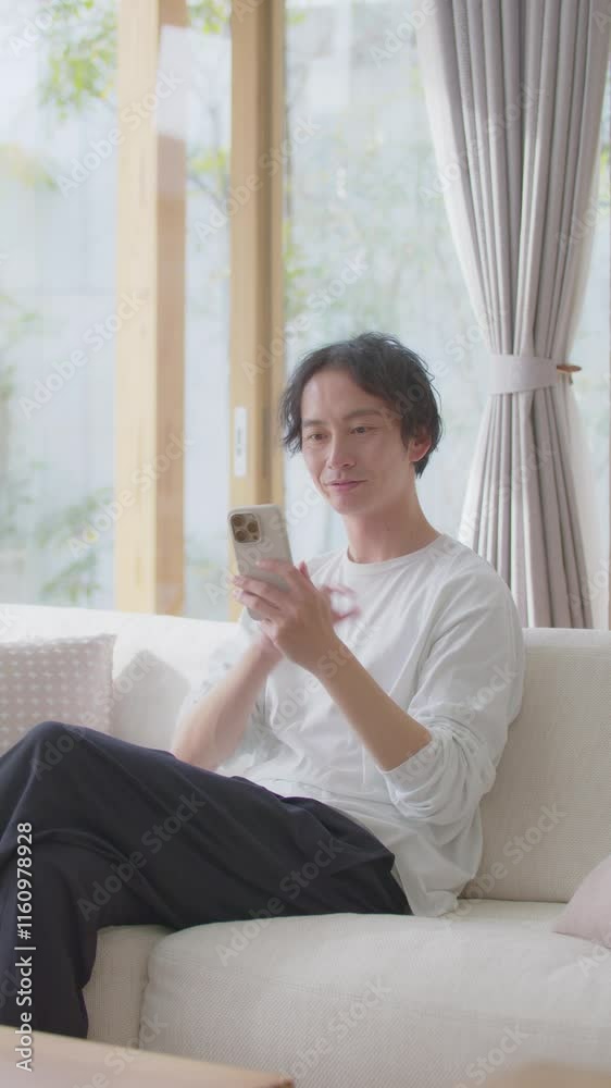 男性・スマホ・ソファ・縦動画 男性・スマホ・ソファ・縦動画