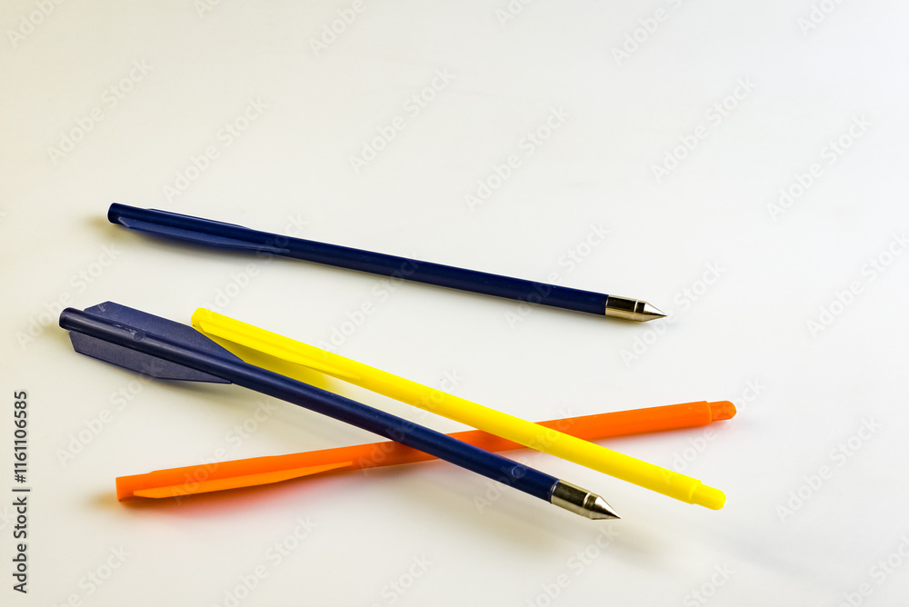 Arrows for a training crossbow on a white background. Arrows with and without tips. Blue, yellow and orange. Arrows for a training crossbow on a white background. Arrows with and without tips. Blue, yellow and orange.