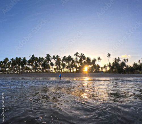 sunset on the beach and girl with surfboard photo