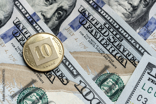 Close-up of a Israel shekel coin on US 100 dollar bills in focus. photo