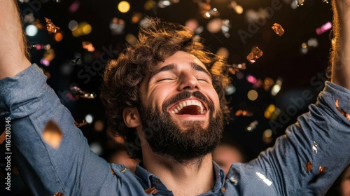 A joyful man celebrates with his arms raised high, surrounded by confetti and vibrant lights, This image captures the essence of happiness at parties or events photo