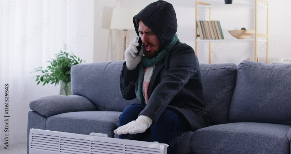 Unhappy man wrapped in warm coat near heater making phone call to service, freezing, renter complaining of low temperature in apartment, feel cold at home, bad temperature control, breakdown central Unhappy man wrapped in warm coat near heater making phone call to service, freezing, renter complaining of low temperature in apartment, feel cold at home, bad temperature control, breakdown central