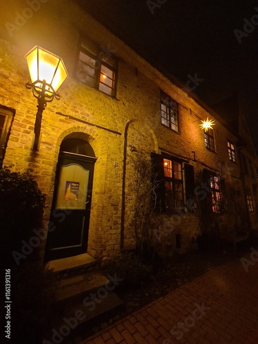 eine schöne Fassade während der Nacht, in Rostock, mit schönem Laternenlicht - wie aus einem Märchen