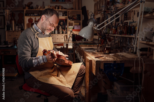 Fotografía Italian violin maker restoring violin in his workshop in cremona