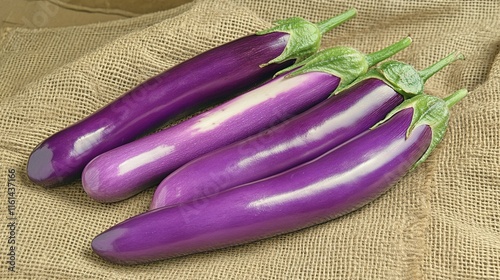 Rustic Wooden Surface with Glossy Purple Eggplants on Burlap Sack for Farm-Fresh Look photo