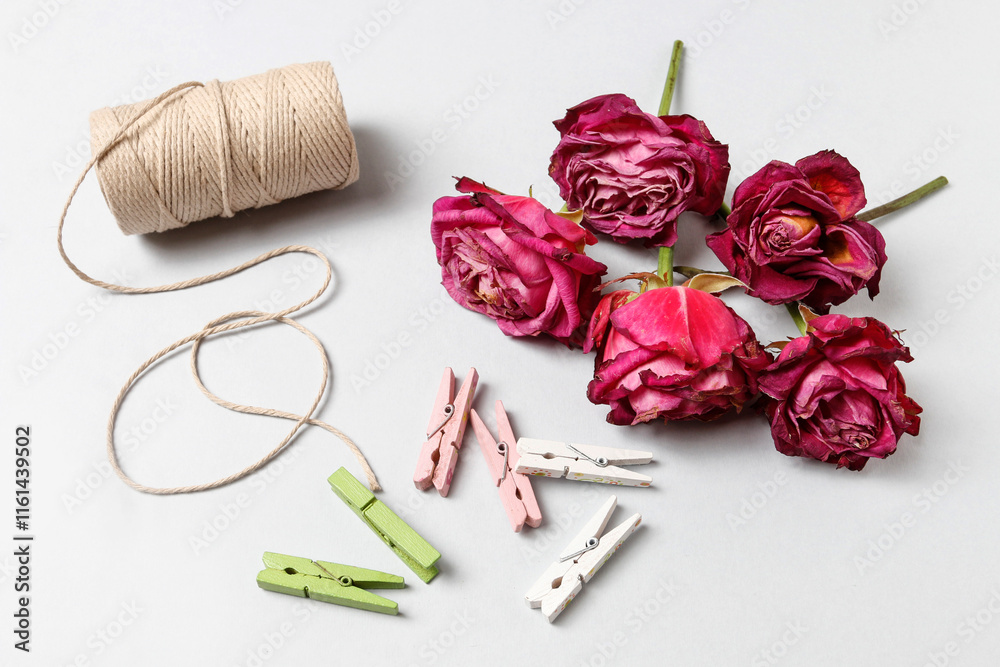 Florist at work: woman shows how to make a simple Valentine's Day decoration with semi-dry roses, string and clothes pegs. Step by step, tutorial.