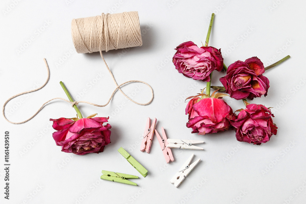 Florist at work: woman shows how to make a simple Valentine's Day decoration with semi-dry roses, string and clothes pegs. Step by step, tutorial.