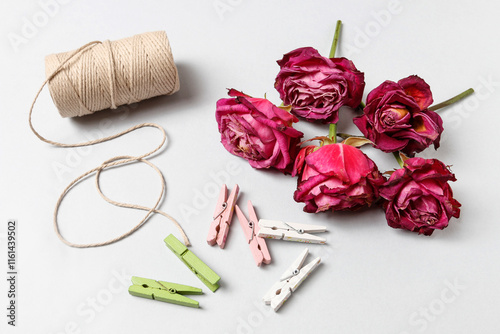 Obraz na płótnie Florist at work: woman shows how to make a simple Valentine's Day decoration with semi-dry roses, string and clothes pegs. Step by step, tutorial. w salonie