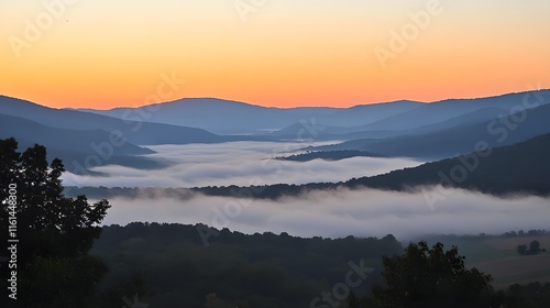 Serene sunrise over a valley shrouded in mist. Layers of mountains stretch to the horizon, painted in soft hues of orange and blue. A peaceful, picturesque landscape.