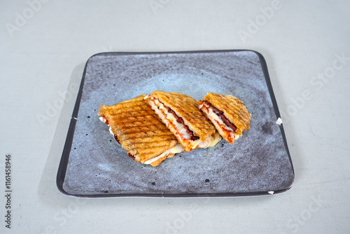 Turkish karisik atom kare  tost ( kasarli bazlama tost) . Sucuklu, Kasarli,  cheddarli, kavurmali karisik tost. Flat baked bread toasted. Karisik bazlama tost . photo