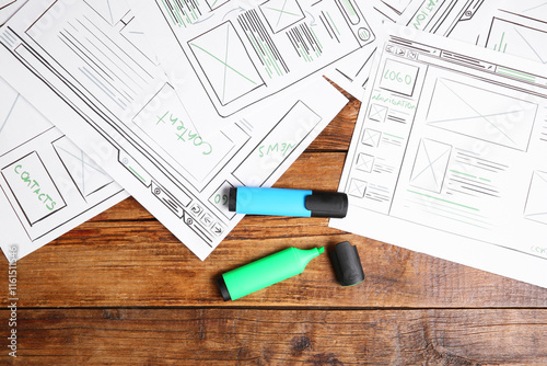 Developing UI design. Sketches of website wireframes and felt pens on wooden table, top view photo