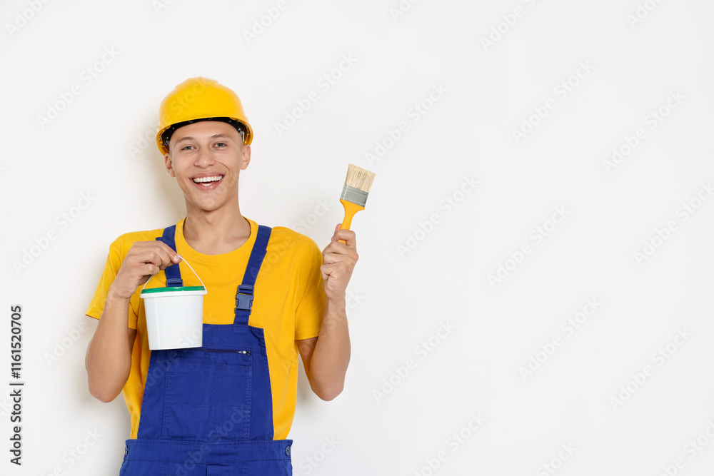 Portrait of young decorator with paint bucket and brush on white background, space for text Portrait of young decorator with paint bucket and brush on white background, space for text